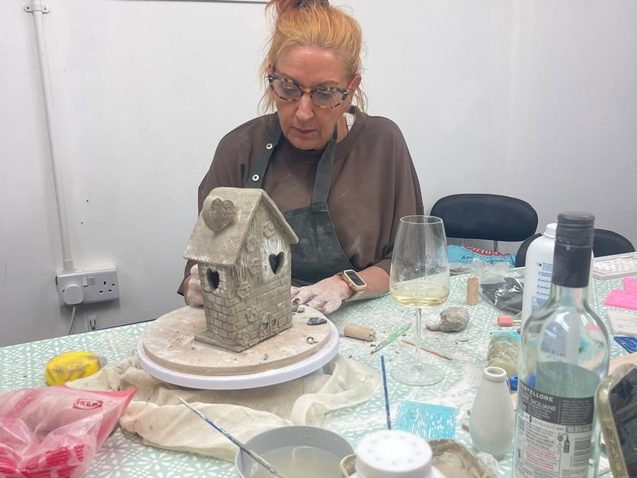 A clay house on a banding wheel at the end of a session